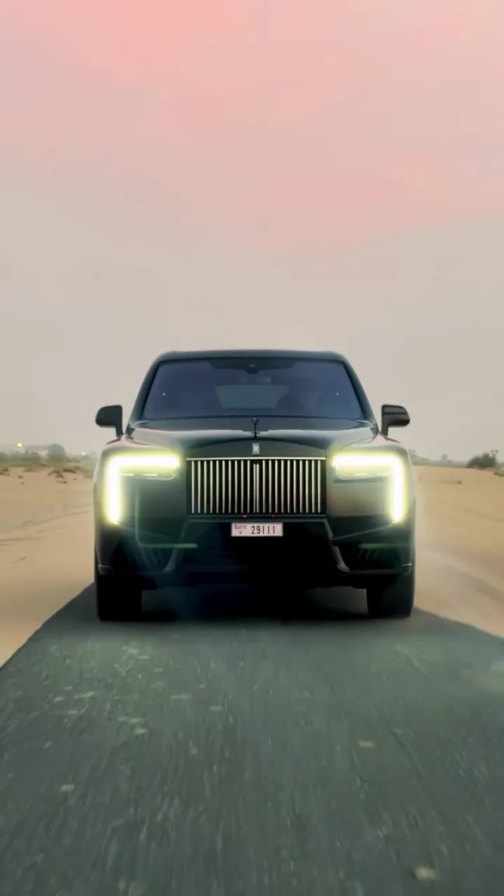 The Cullinan's headlights on a desert road at dusk